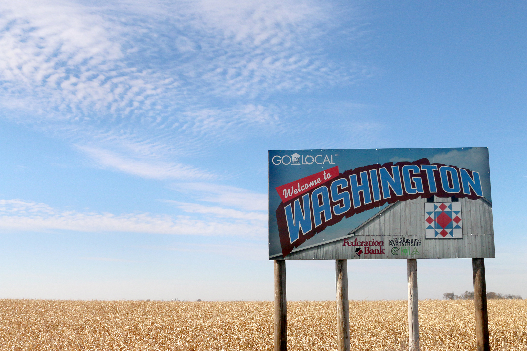 Washington town sign in front of a corn field. 