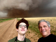 Stephen and Mike Cross with a giant tornado behind them. 