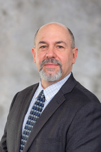 Headshot of Jim Chaffee with a grey background.