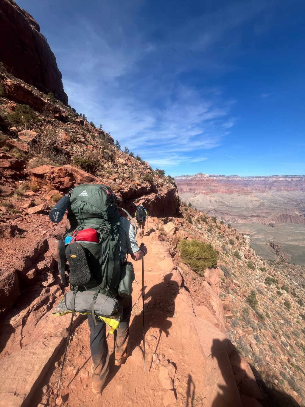 A hiker treks along a cliff in the Grand Canyon