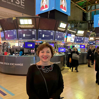 Deniz Johnson on the NYSE floor wtih her photo on the big screens above.