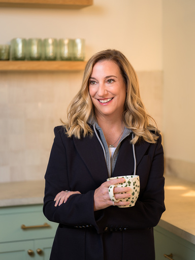 Nicole Otto at Ruggable headquarters in California, standing in a kitchen with a cup of coffee.