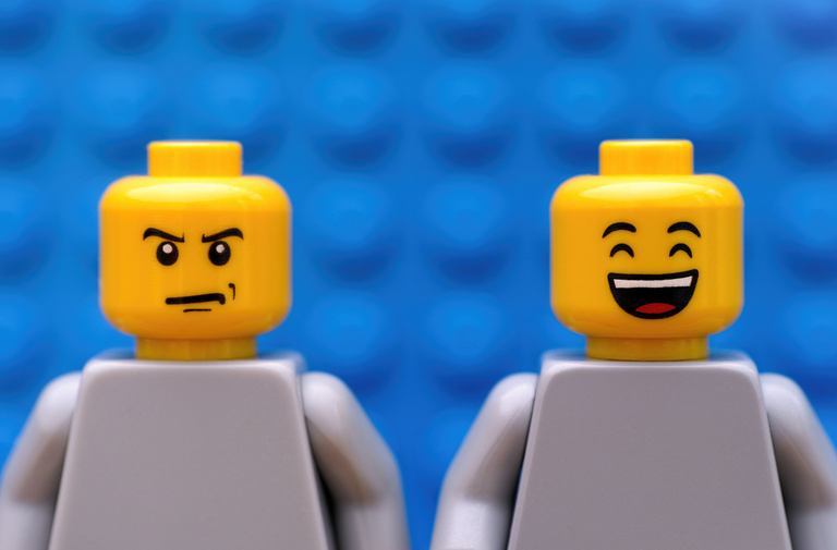 Two Lego people, one smiling one frowning