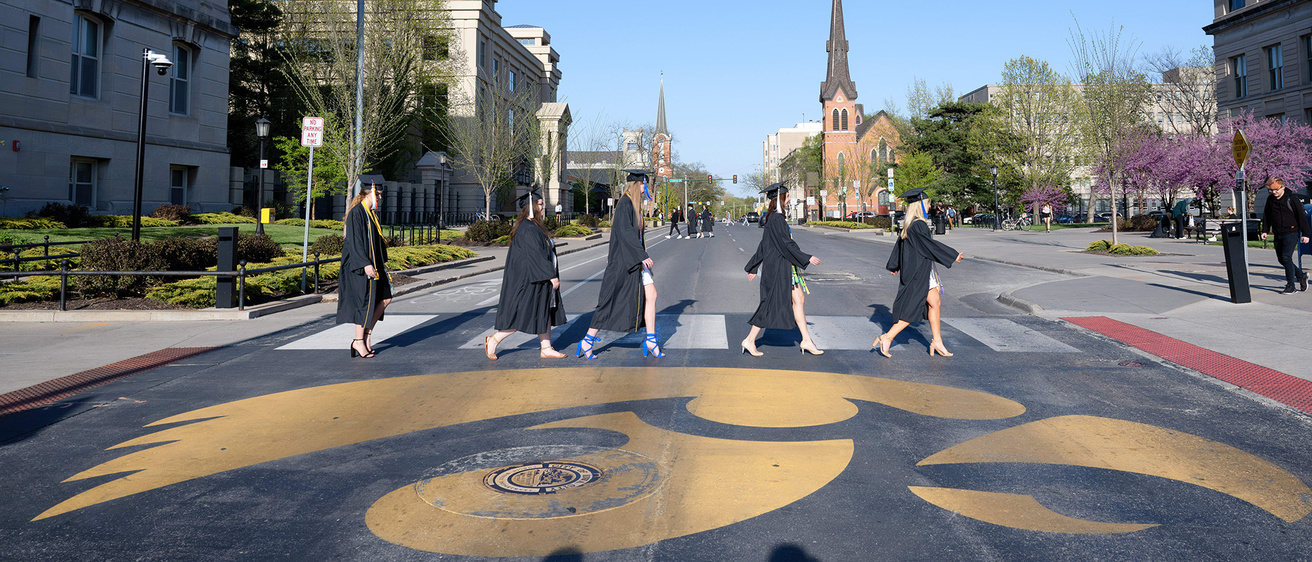 UI graduates walking across the street