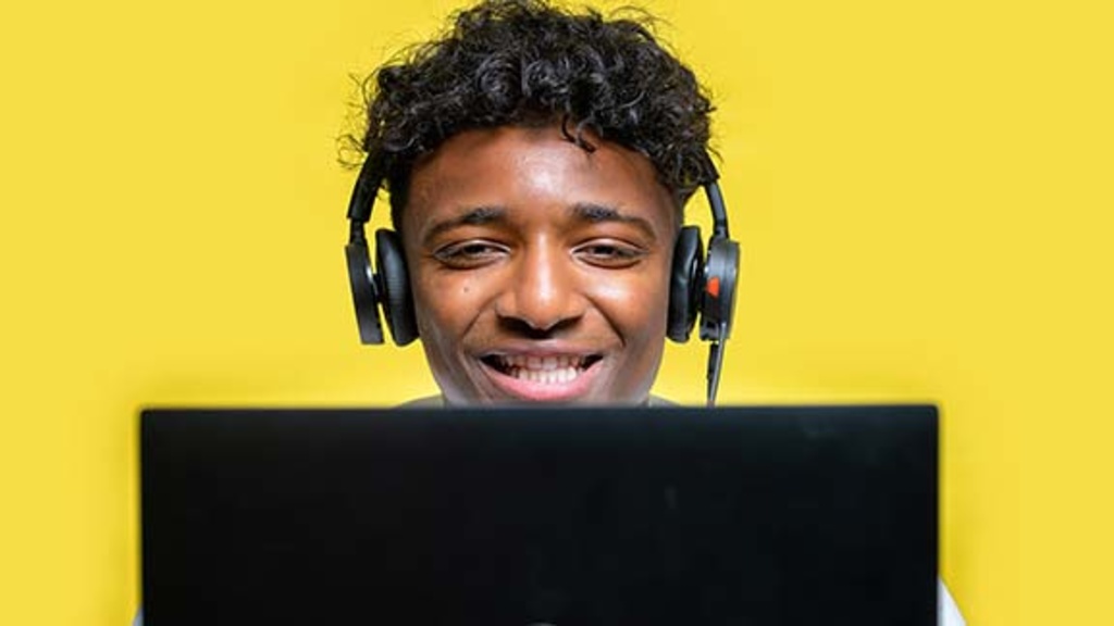 Student at a laptop, wearing headphones