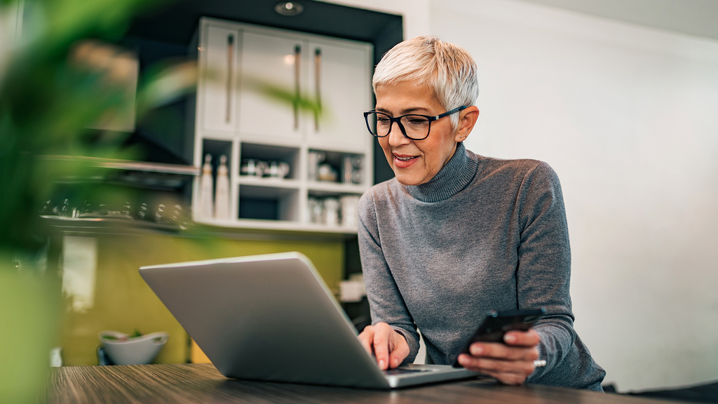 woman with gray hair looking at laptop