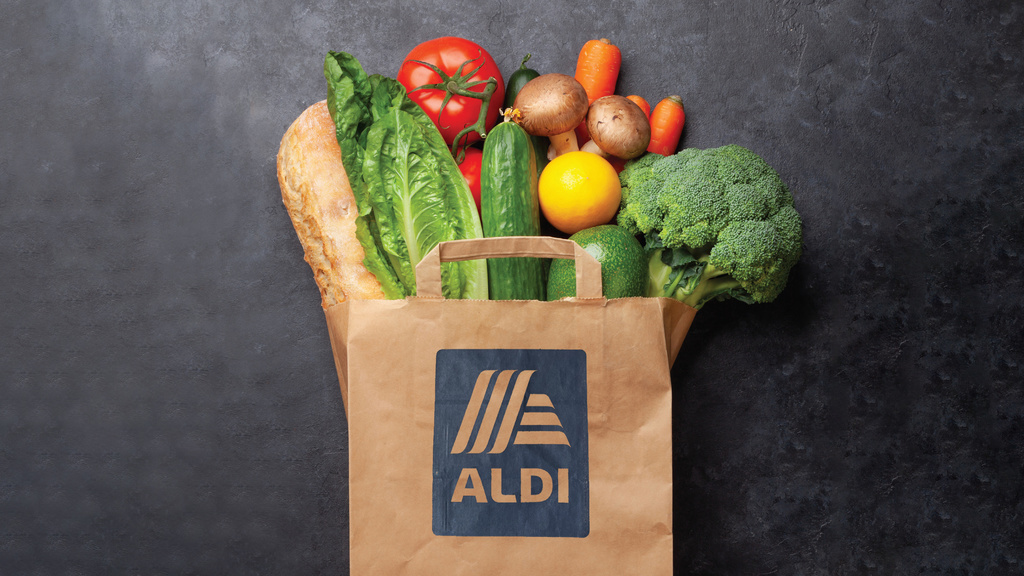 Paper grocery bag with ALDI logo and food sticking out of the top. 
